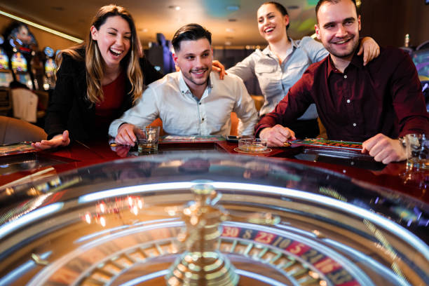 Excited group of friends playing roulette in casino