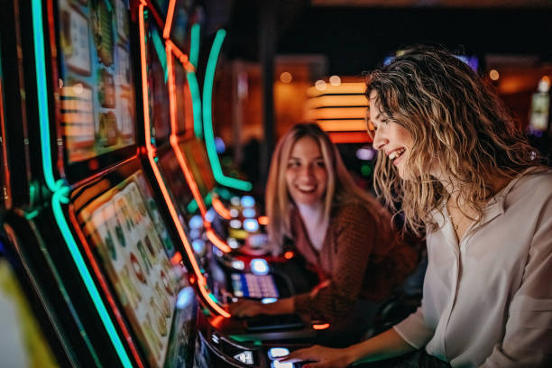 Girl friends gambling in casino on slot machinery